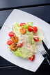 Fresh caesar salad on white bowl with parmesan cheese and shrimps