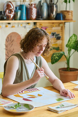 Aufkleber - Young female with paintbrush over paper working over new abstract painting in workshop while using gouache of various colors