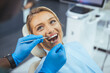 © Dragana Gordic - Perfect smile! Part of dentist examining his beautiful patient in dentist office. European young woman smiling while looking at mirror in dental clinic