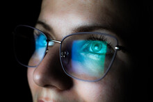 Girl Works On Internet. Reflection At The Glasses From Laptop..Close Up Of Woman's Eyes With Black Female Glasses For Working At A Computer. Eye Protection From Blue Light And Rays.