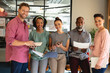 © Wavebreak Media - Portrait of smiling multiracial colleagues with documents during meeting in creative office