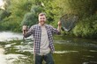 Fly-fisherman holding trout out of the water