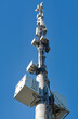 Leinwandbild Motiv Telecommunication cell tower antenna against blue sky. Wireless communication and modern mobile internet. Bottom view.