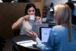 © Wavebreak Media - Asian businesswoman drinking coffee while working late with caucasian colleague in office at night