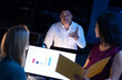 © Wavebreak Media - Multiracial businessman discussing with female workers while working late in modern office at night
