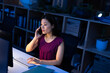 © Wavebreak Media - High angle view of asian businesswoman talking on smartphone and using computer at desk in office