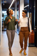 © wavebreak3 - Multiracial businesswomen discussing while walking in corridor of office building