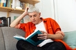 © ADDICTIVE STOCK - Androgynous Man Reading Book Sitting On Sofa