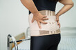 Asian lady patient wearing back pain support belt for orthopedic lumbar.