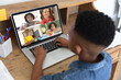 © vectorfusionart - African american boy looking at laptop screen with multiracial students during online class
