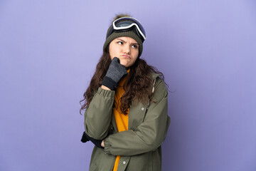 Wall Mural - Teenager Russian girl with snowboarding glasses isolated on purple background having doubts while looking up