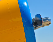 A Closeup Of An Engine Cowling And Propeller Of A Biplane.