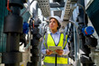 © narong - Portrait of engineer or technician worker woman stay in area of pipe network with day light and also look at the right side in constuction area.