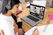 © vectorfusionart - Biracial teenage girl wearing headphones writing while following professor teaching in online class