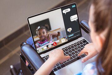 Canvas Print - Caucasian girl learning from online class over video call on laptop while sitting on wheelchair