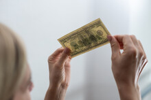 Woman Holding Dollar Bill And Looking At It With Watermarks Closeup.