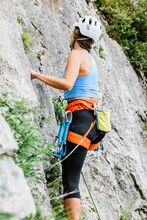 Unrecognizable Female Climber Ascending On Cliff In Summer