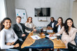 canvas print picture Portrait of successful multiracial business team sitting in modern office. Group of business people work together, smiling, look at the camera, teamwork concept