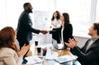 © Kateryna - Business partnership.Successful people make agreement after negotiation.African american businessman shake hands with caucasian businesswoman,sign a contract at briefing meeting, collaboration concept