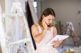 Fototapeta  - Young woman construction manager checking project documentation while working in apartment.