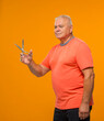 © serhii - an elderly man with scissors in his hands cuts something on a yellow background isolated