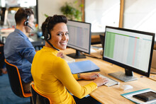 Portrait Of Smiling Caucasian Female Customer Service Executive With Computer In Office