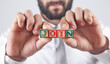 © andranik123 - Man holding a wooden cubes with the message Join.