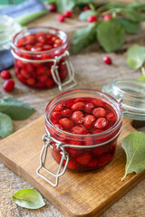 Homemade dogwood jam on a wooden background. Organic jam, healthy food.