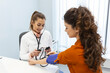 © Graphicroyalty - Doctor using sphygmomanometer with stethoscope checking blood pressure to a patient in the hospital.