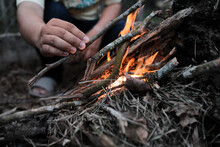 Close Up View Of A Hand Lighting Up A Fire While Camping In The Forest