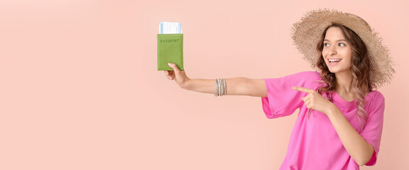 Wall Mural - Beautiful female tourist holding passport and tickets on pink background with space for text