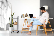 Handsome Barefoot Man Using Laptop At Home