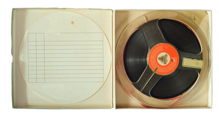 Vintage magnetic audio reel in cardboard box and blank paper tracklist inlay, free copy space.