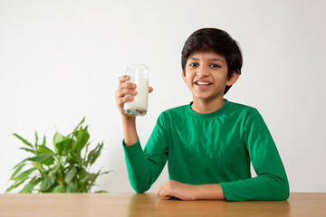 Portrait of smiling boy drinking milk during breakfast