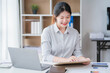 © Kritdanai - Young asian businesswoman beautiful charming smiling and talking on the mobile phone in the office