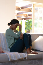 Stressed African American Young Woman With Head In Hand Sitting On Sofa At Home, Copy Space