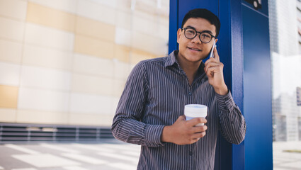 Guy talking on smartphone on bus stop in city