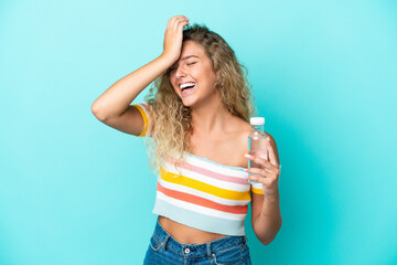 Wall Mural - Young blonde woman with a bottle of water isolated on blue background has realized something and intending the solution