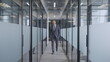 © Synthex - Successful businessman walking along office corridor with glass walls and doors