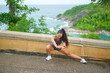 © tonefotografia - A Beautiful fit woman in sportswear exercising on seaside mountain peak, Health and Travel concept.