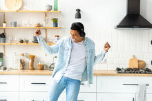 Happy Carefree Freedom Young Man In Headphones Dancing At Home In The Kitchen Alone Having Fun