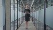 © Synthex - Successful businesswoman walking in company office corridor, tablet in hands