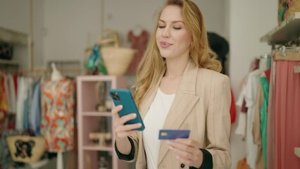 Poster - Young blonde woman customer using smartphone and credit card at clothing store