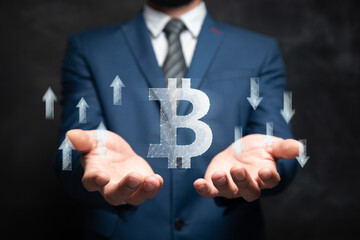 Wall Mural - Icon of bitcoin and arrows up and down from the network. Man holding in his hand