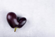 Heart shaped ugly eggplant isolated on concrete grey background, funny aubergine vegetables for a healthy diet with copy space, Funny unnormal vegetable concept