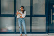 © carballo - latin girl with headphones on mobile phone or smartphone in the street