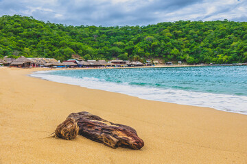 Huatulco bays - Maguey beach. Beautiful beach with pristine waters, with turtles and fishes. Mexican beach with wooden huts by the sea