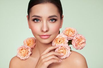 Portrait beautiful young woman with clean fresh skin. Model with healthy skin, close up portrait. Cosmetology, beauty and spa. Girl with a rose flower