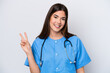 © luismolinero - Young Brazilian nurse woman isolated on white background smiling and showing victory sign