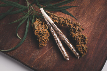 Rolled CBD medicinal marijuana and flower on wood background